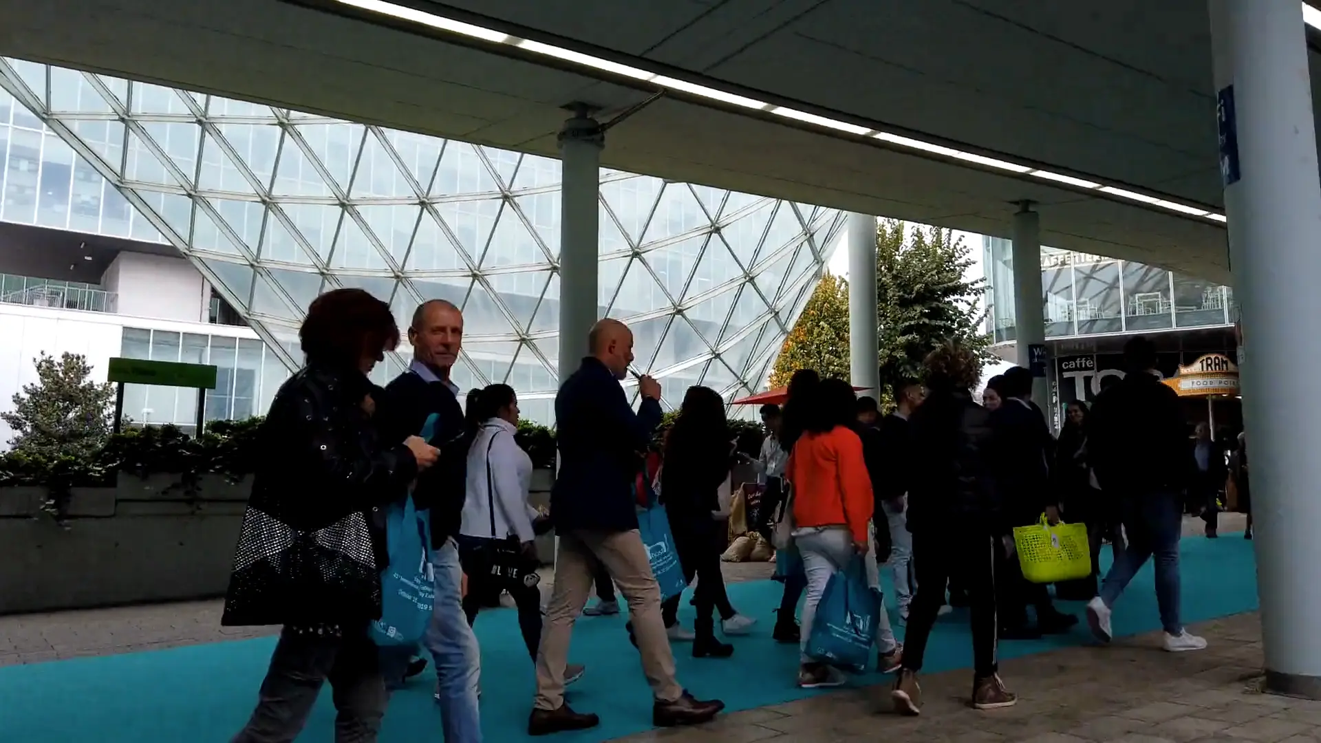 Delegates arriving at a large conference walking around the concourse